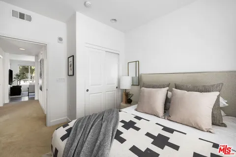 a bedroom with a bed and mirror