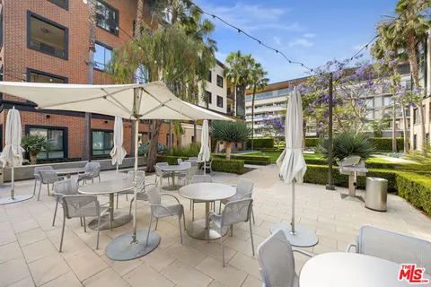 a view of a patio with couches table and chairs and potted plants