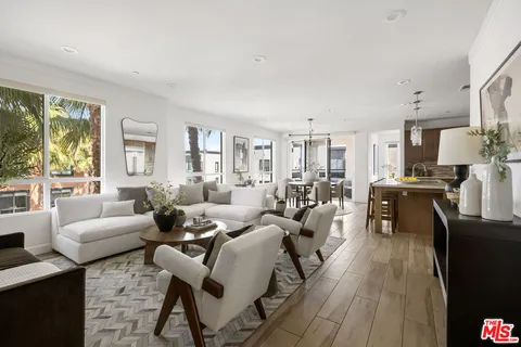 a living room with fireplace furniture and a large window