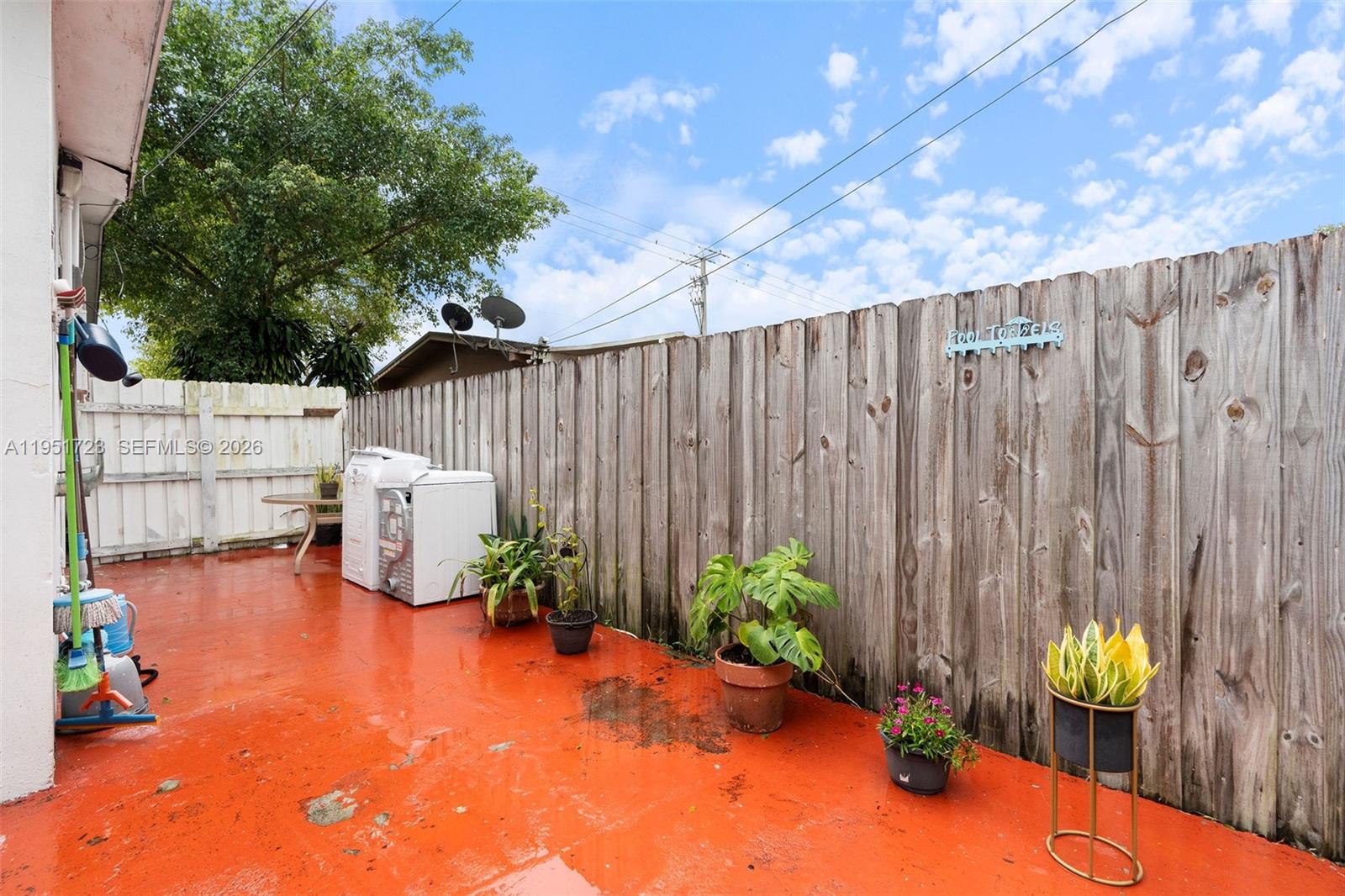 9601-9603 Southwest 36th Street Miami, FL 33165 - Photo 11 of 45 a view of a backyard with table and chairs potted plants with wooden fence