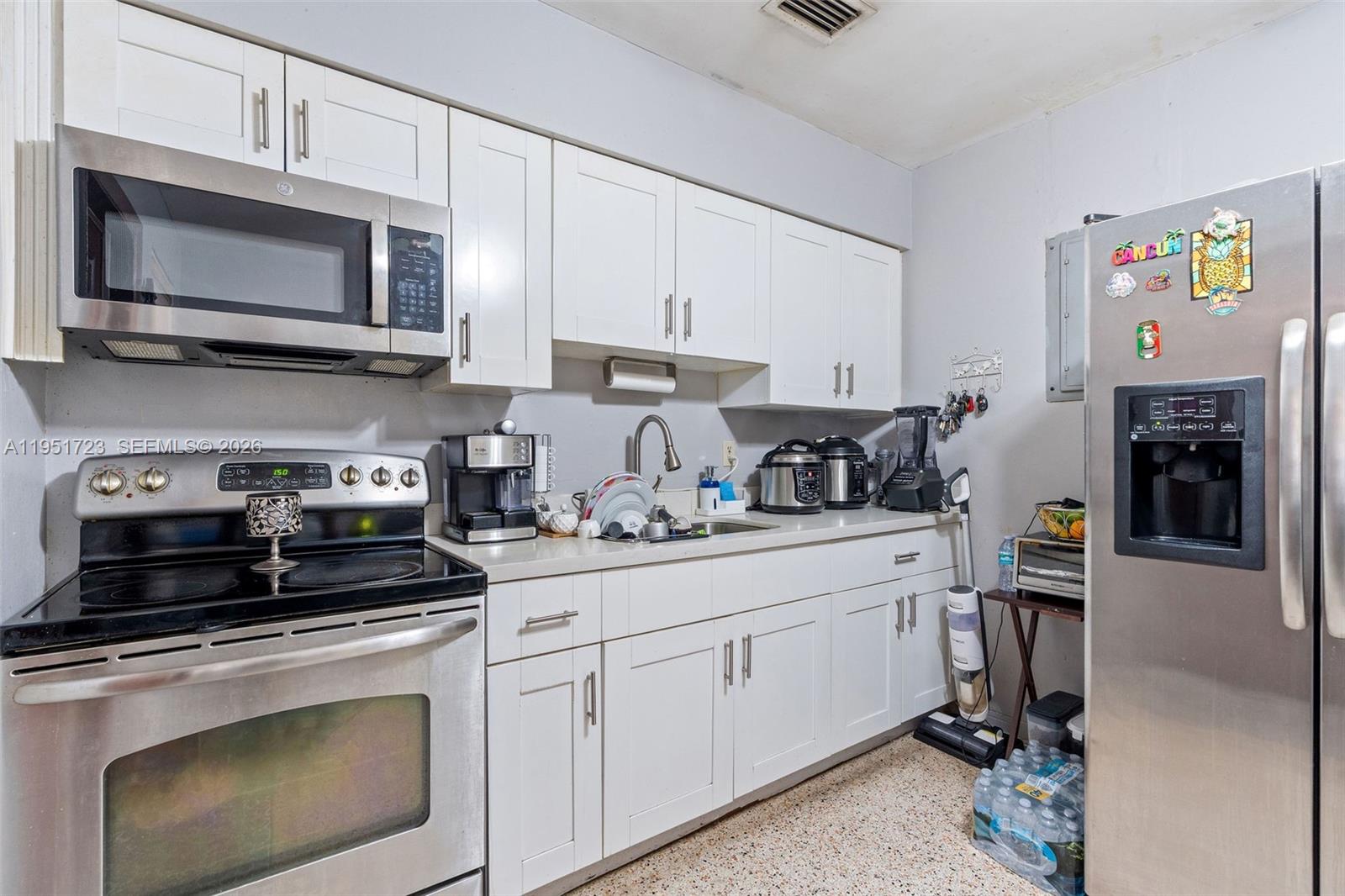 9601-9603 Southwest 36th Street Miami, FL 33165 - Photo 28 of 45 a kitchen with stainless steel appliances granite countertop a stove a microwave and cabinets
