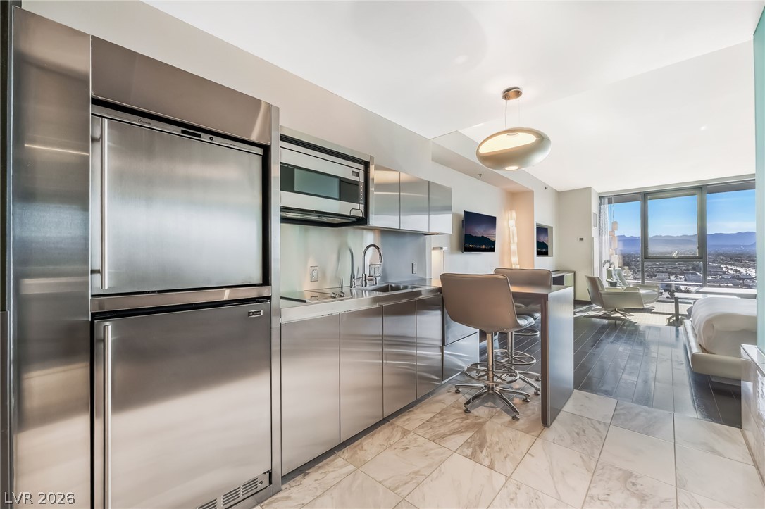 4381 West Flamingo Road, Unit 18305 Las Vegas, NV 89103 - Photo 2 of 19 A streamlined kitchen with a breakfast bar provides a functional space with captivating mountain and city views.