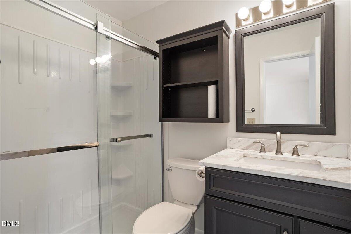 163 Springberry Lane Chapel Hill, NC 27517 - Photo 19 of 32 a bathroom with a granite countertop sink toilet a mirror and shower