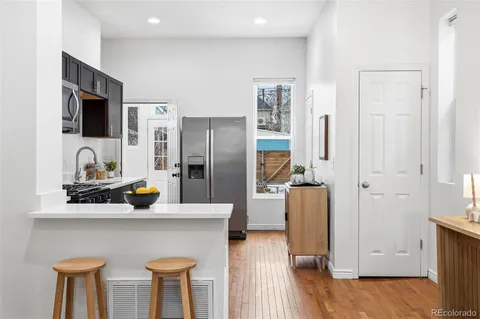 a kitchen with stainless steel appliances granite countertop a refrigerator a stove and a sink
