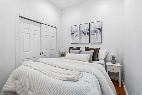 a bedroom with a bed and painting on the wall