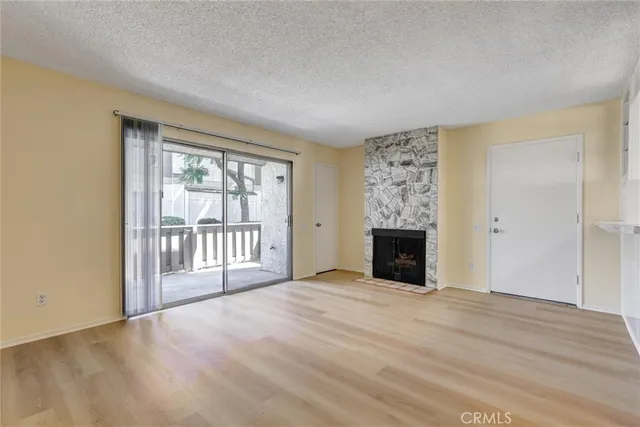 a view of an empty room with a window and fireplace