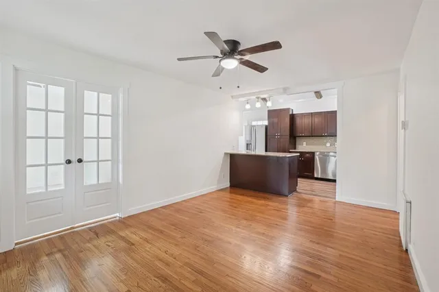 a view of a livingroom with a ceiling fan and wooden floor