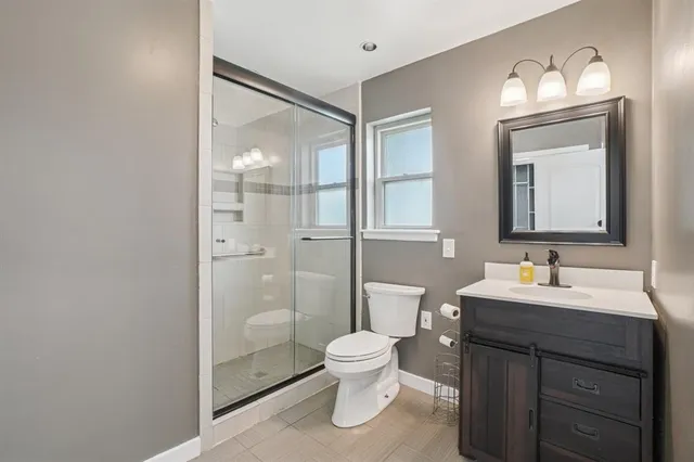 a bathroom with a toilet sink a mirror and shower