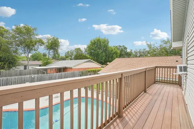 a view of a balcony with wooden floor and fence