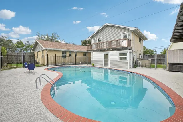 a view of a white house with a swimming pool