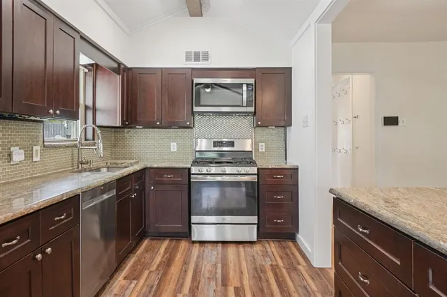 a kitchen with stainless steel appliances granite countertop a stove and a sink