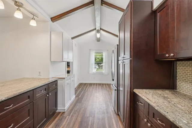 a kitchen with a sink a refrigerator and chandelier