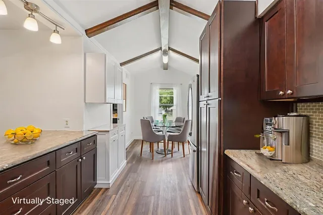 a kitchen with granite countertop white cabinets and stainless steel appliances