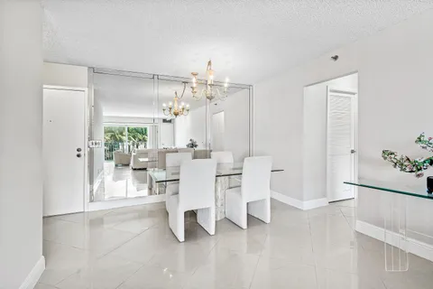a living room with furniture a chandelier and a dining table