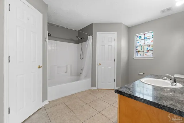 a bathroom with a granite countertop sink a mirror and a bathtub