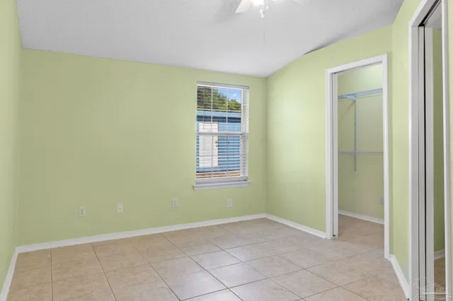 an empty room with closet and a chandelier fan