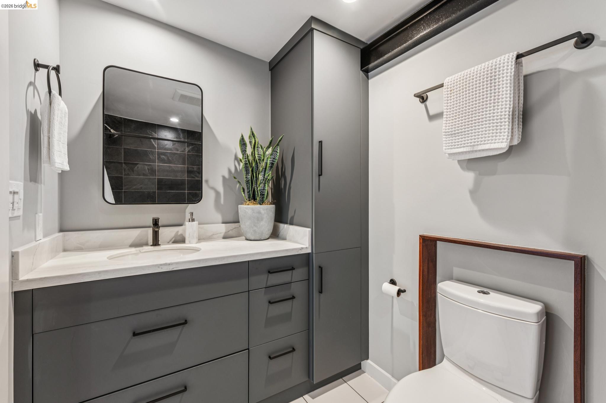 829 21st Street, Unit 1 Oakland, CA 94607 - Photo 32 of 46 a bathroom with a toilet sink and mirror
