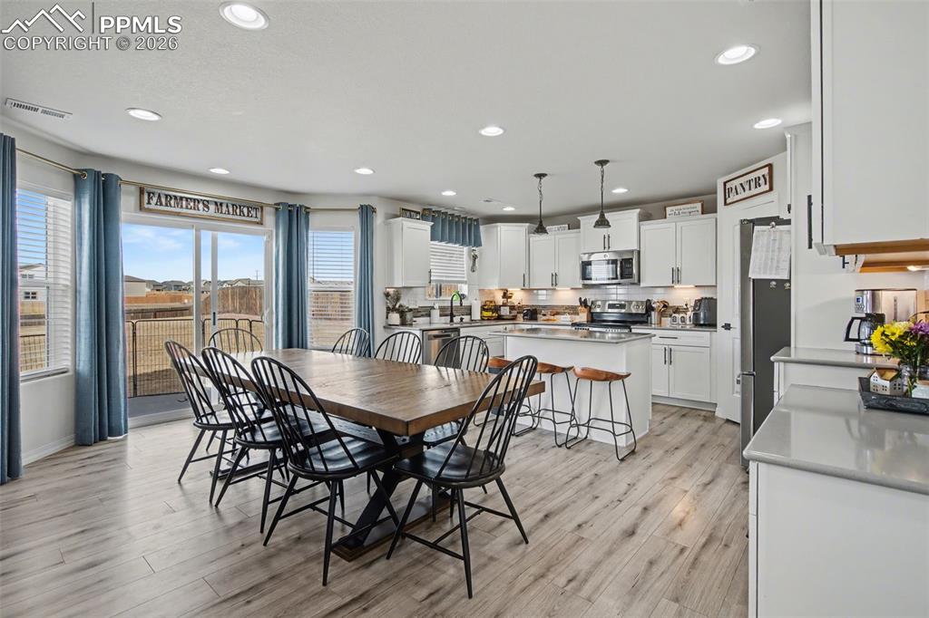 7811 Berwyn Loop Peyton, CO 80831 - Photo 11 of 38 a kitchen with stainless steel appliances granite countertop a kitchen island a stove a table and a refrigerator