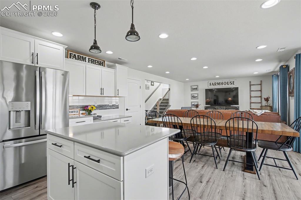 7811 Berwyn Loop Peyton, CO 80831 - Photo 12 of 38 a kitchen with stainless steel appliances granite countertop a refrigerator a sink a stove a dining table and chairs