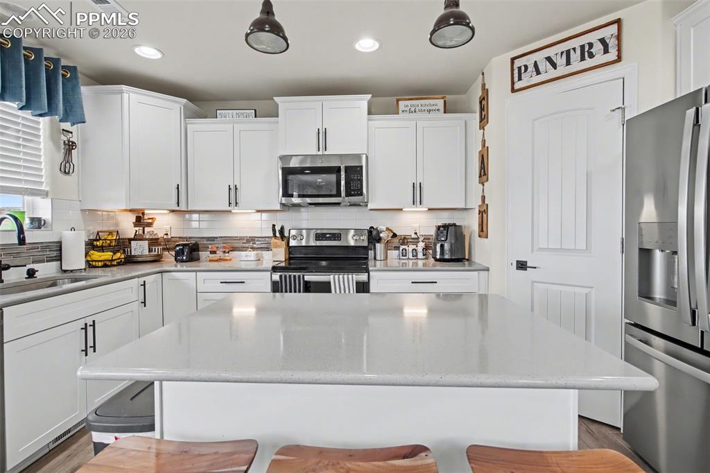 7811 Berwyn Loop Peyton, CO 80831 - Photo 14 of 38 a kitchen with stainless steel appliances granite countertop a refrigerator a stove top oven a sink and dishwasher
