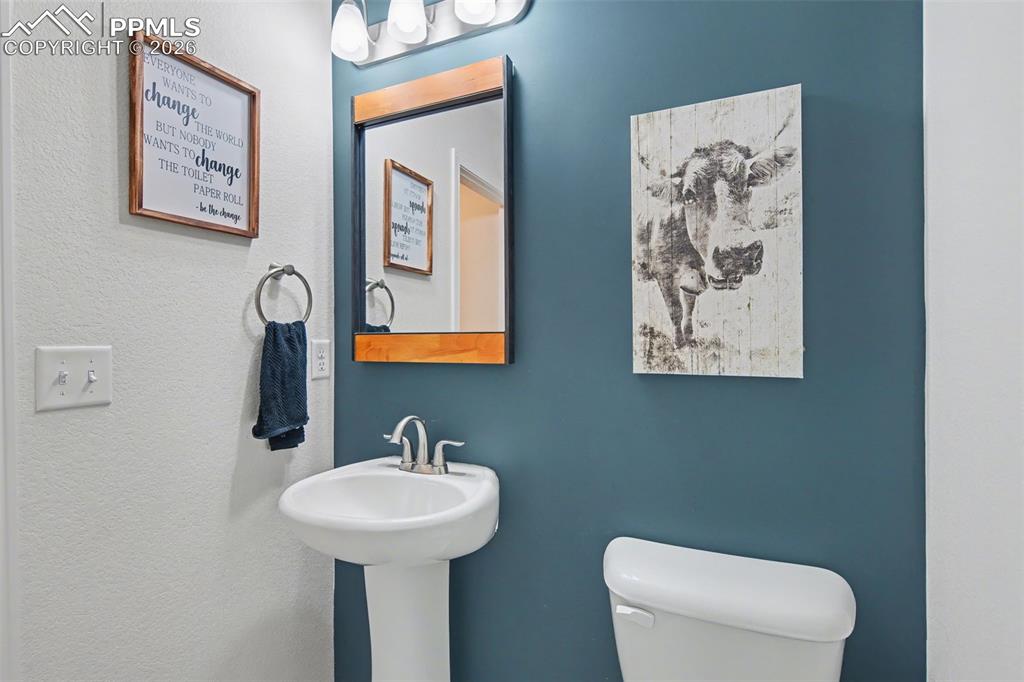 7811 Berwyn Loop Peyton, CO 80831 - Photo 19 of 38 a bathroom with a toilet sink and mirror