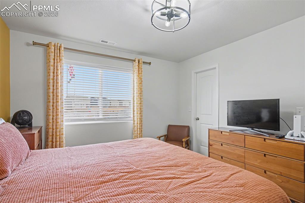 7811 Berwyn Loop Peyton, CO 80831 - Photo 31 of 38 a bedroom with a bed and a flat screen tv
