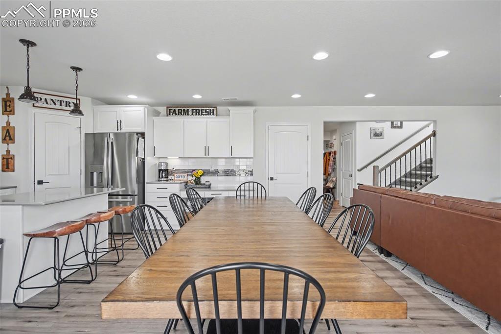 7811 Berwyn Loop Peyton, CO 80831 - Photo 10 of 38 a dinning room and kitchen with furniture a rug and a chandelier