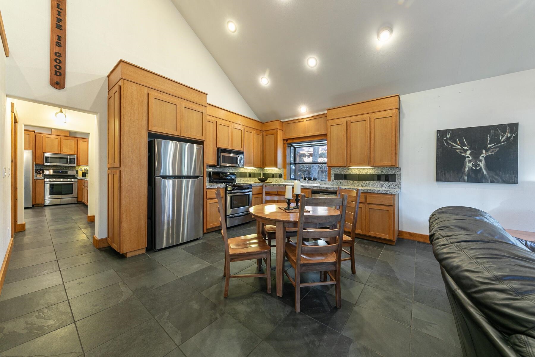 14580 Donner Pass Road Truckee, CA 96161 - Photo 10 of 27 a kitchen with stainless steel appliances a refrigerator a stove a sink a dining table and chairs