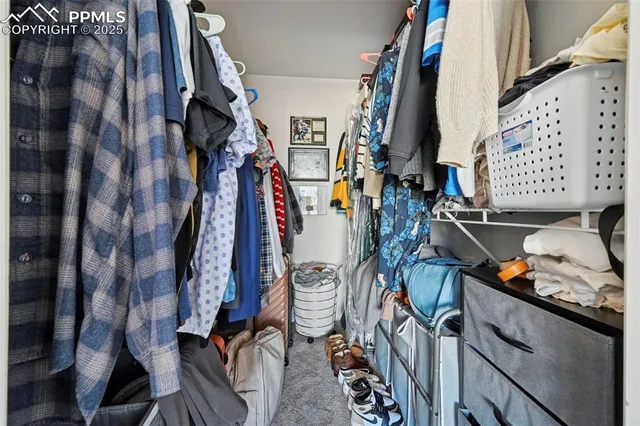 a view of walk in closet with clothes