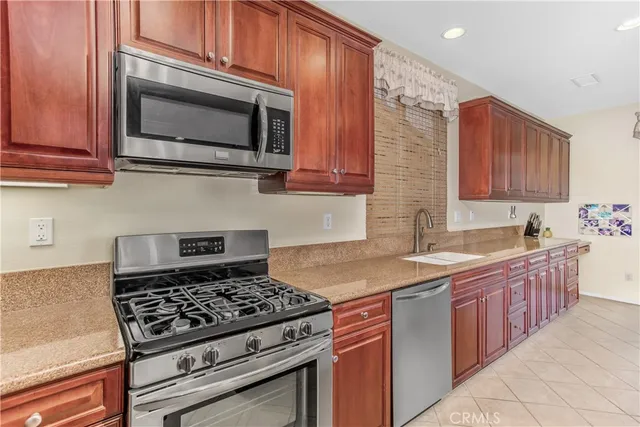 a kitchen with stainless steel appliances granite countertop a sink stove and microwave