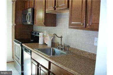 2801 Logway Road Vienna, VA 22181 - Photo 3 of 5 a kitchen with stainless steel appliances granite countertop a sink and a refrigerator