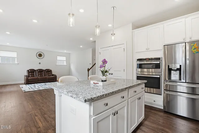 a kitchen with stainless steel appliances granite countertop a sink refrigerator and cabinets