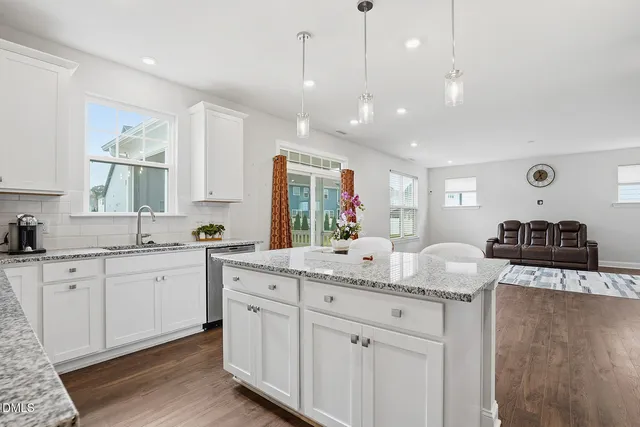 a kitchen with granite countertop white cabinets and a sink