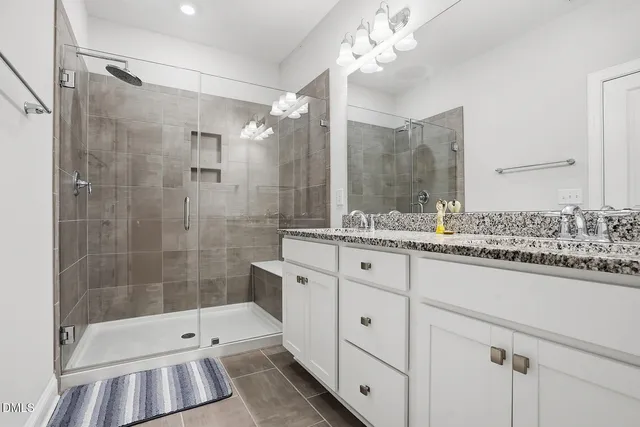 a bathroom with a shower sink and mirror