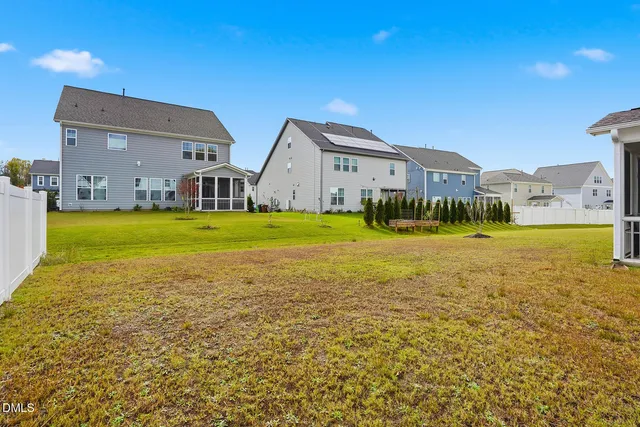 a view of a house with a big yard and large trees