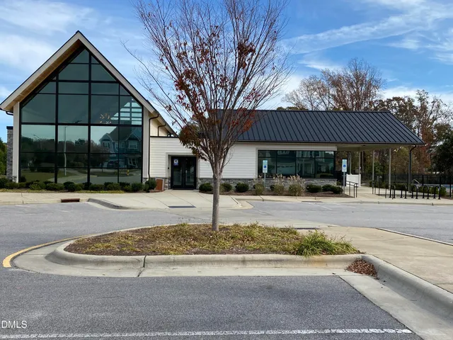 a view of a white house with a large windows yard and palm tree