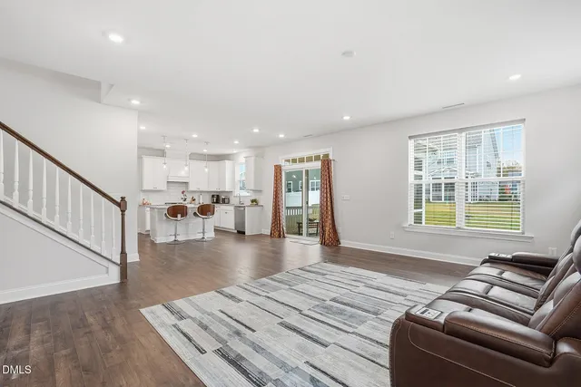 a living room with furniture and a table with wooden floor