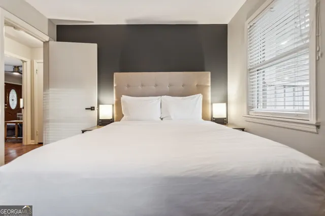 a bedroom with a bed and a refrigerator