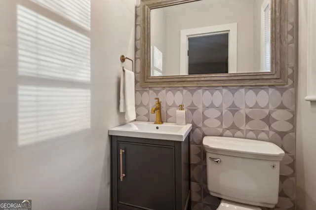 a bedroom with a painting on the wall and a window