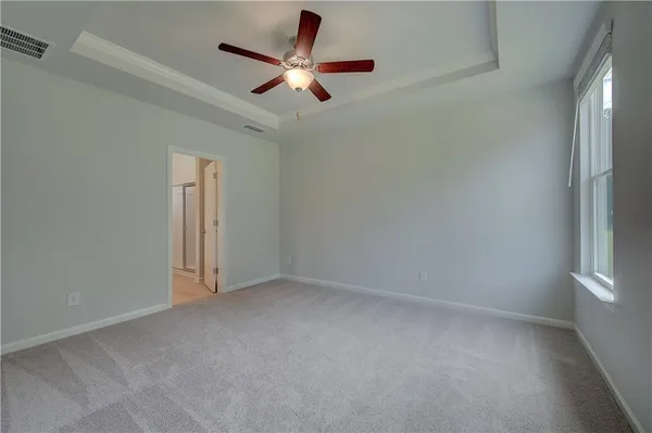 an empty room with a ceiling fan and window