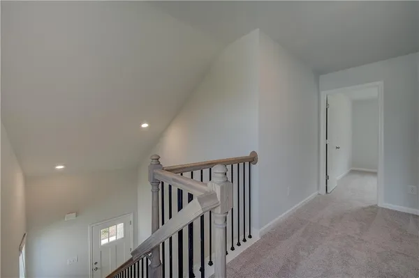 a view of staircase with railing and white walls