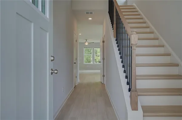 a view of a hallway with wooden floor and entryway