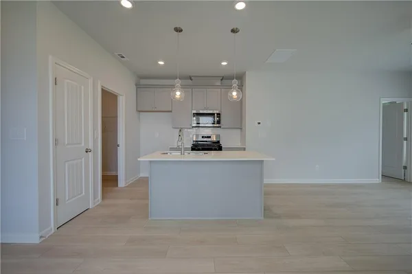 a view of kitchen with granite countertop refrigerator and sink