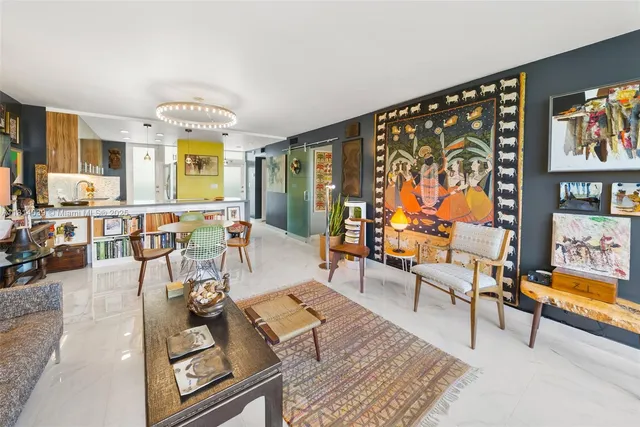 a living room with furniture and painting on the wall next to a window