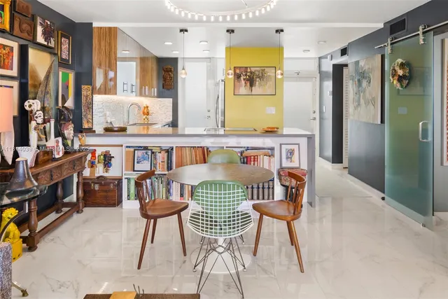 a dining room with stainless steel appliances a table and chairs