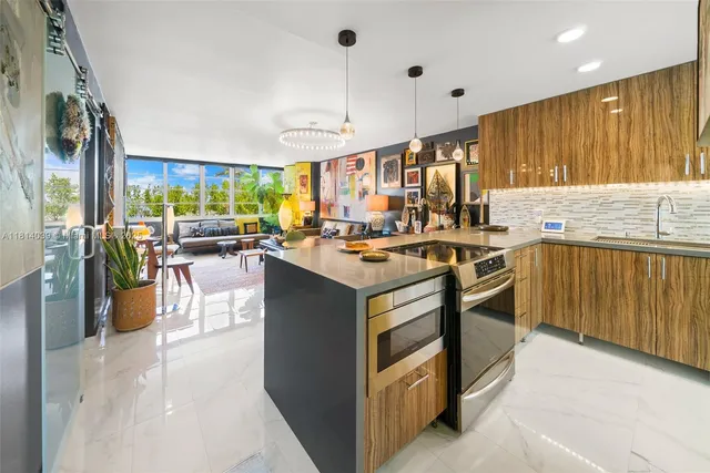 a kitchen with stainless steel appliances granite countertop a stove refrigerator sink and cabinets