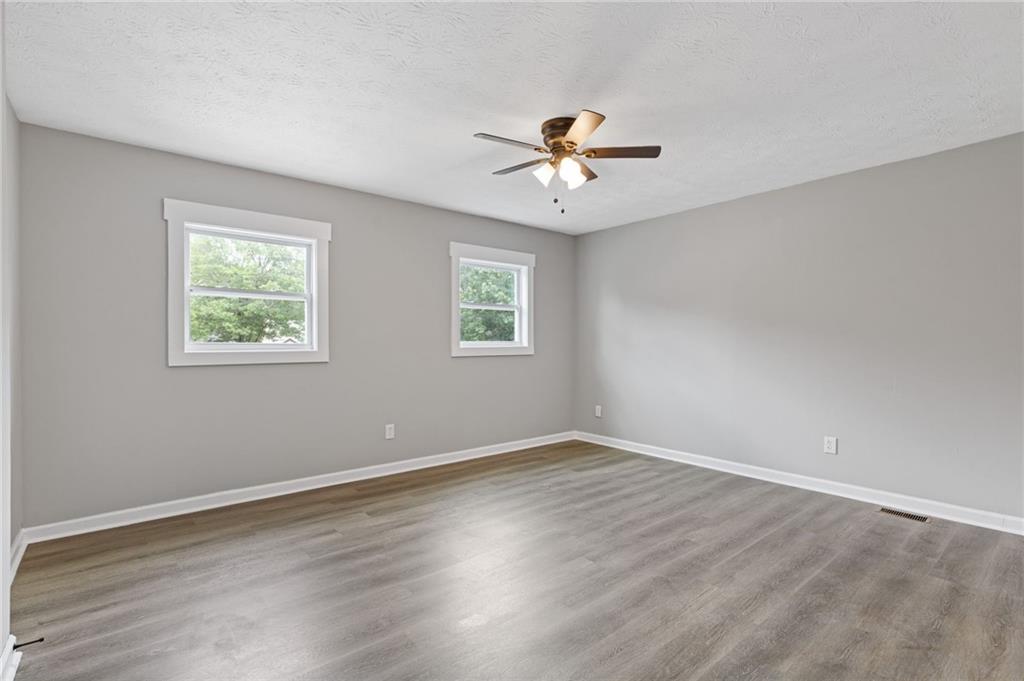 1164 Red Oak Cove Tucker, GA 30084 - Photo 13 of 24 a view of an empty room with a window and wooden floor