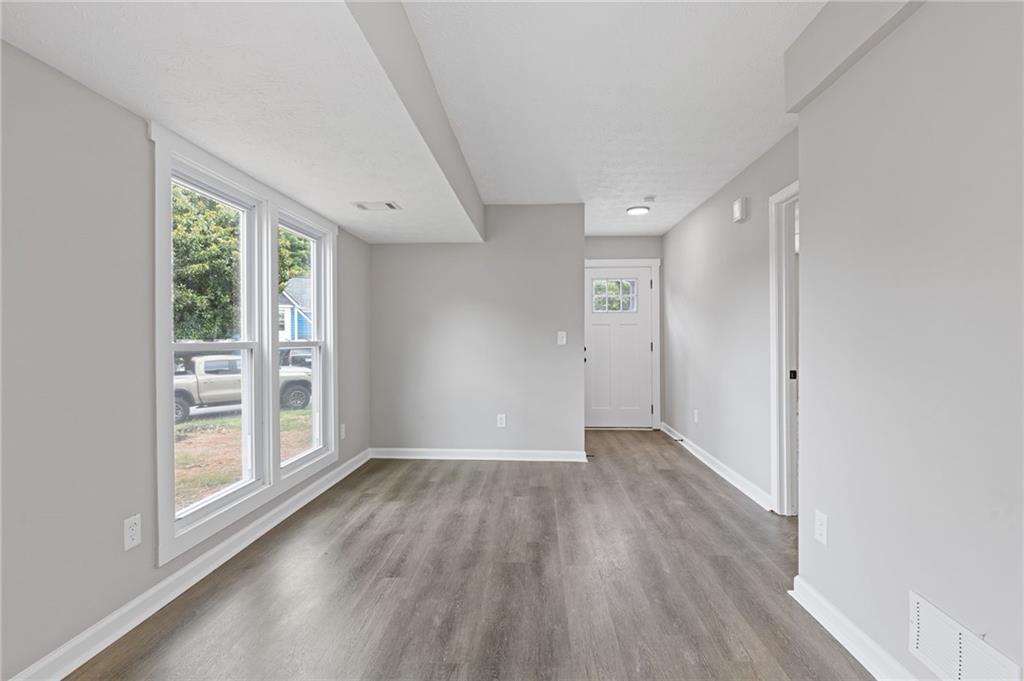 1164 Red Oak Cove Tucker, GA 30084 - Photo 5 of 24 an empty room with wooden floor and windows