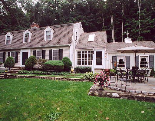 8 River Road Weston, CT 06883 - Photo 1 of 1 a front view of a house with a yard table and chairs