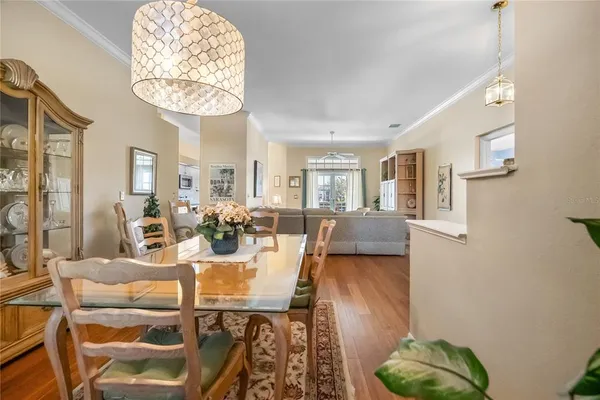 a view of a dining room with furniture a chandelier and wooden floor